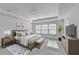 Bright bedroom with large windows, tray ceiling, and neutral decor offers a relaxing retreat at 2054 Hickman Walk, Suwanee, GA 30024