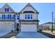 Charming townhome with a two-car garage, stone accents, and lovely curb appeal at 2054 Hickman Walk, Suwanee, GA 30024