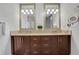 Elegant bathroom featuring double sinks, dark wood cabinetry, and bright lighting fixtures at 4561 Olde Perimeter Way # 702, Atlanta, GA 30346