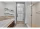 Bright bathroom boasts a soaking tub, glass shower, and a walk-in closet with custom built-ins at 4561 Olde Perimeter Way # 702, Atlanta, GA 30346