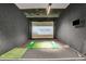 Modern golf simulator room with a large screen and putting green at 4561 Olde Perimeter Way # 702, Atlanta, GA 30346