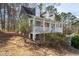 Exterior shot showcases trees surrounding home and front covered porch at 55 Legend Creek Cove, Douglasville, GA 30134