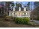 Charming front view of home, nestled in a wooded lot, featuring a covered porch and well-maintained yard at 55 Legend Creek Cove, Douglasville, GA 30134