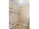 This laundry room features shelving, tile flooring, and washer/dryer hookups at 55 Legend Creek Cove, Douglasville, GA 30134
