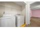 Laundry room with washer, dryer, shelving, and yellow flooring at 125 Fairhaven Trl, Fairburn, GA 30213