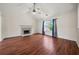 Bright living room featuring hardwood floors, vaulted ceilings, and a cozy fireplace at 125 Fairhaven Trl, Fairburn, GA 30213