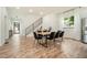 Modern dining room with a sleek black table and chairs, hardwood floors, and an abundance of natural light at 245 Mathewson Pl, Atlanta, GA 30314