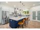 Spacious modern kitchen with white cabinets, stainless steel appliances, blue island, and stylish bar stools at 245 Mathewson Pl, Atlanta, GA 30314