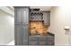 Basement bar area with gray cabinets, sink, and decorative wood backsplash at 2867 Watchtower Approach Nw, Marietta, GA 30064