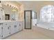 Bathroom with shower, tub, vanity and large window with a custom stained glass pattern at 2867 Watchtower Approach Nw, Marietta, GA 30064