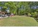 Large backyard with lawn, firepit, dining area, built in grill and mature trees at 3034 Bristlewood Nw Ln, Marietta, GA 30064