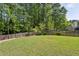 Spacious backyard featuring a well-maintained lawn, privacy fence, and mature trees, ideal for outdoor activities at 3034 Bristlewood Nw Ln, Marietta, GA 30064