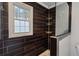 Modern bathroom featuring dark wood-look tile, a walk-in shower, and a frosted window at 3034 Bristlewood Nw Ln, Marietta, GA 30064