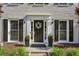 Charming front entry adorned with a wreath, potted plants, and elegant lighting fixtures at 3034 Bristlewood Nw Ln, Marietta, GA 30064