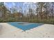 Covered swimming pool surrounded by a concrete deck and wooded area, ensuring privacy and space for relaxation at 3034 Bristlewood Nw Ln, Marietta, GA 30064