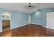 Bright bedroom featuring hardwood floors, blue walls, and a modern light fixture at 621 Spruce Dr, Stone Mountain, GA 30083