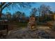 Inviting stone outdoor fireplace, lights, and circular stone features in a lush backyard setting at 1199 Murray Sw Cir, Marietta, GA 30064