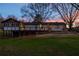 Exterior of the home featuring a stone fireplace, deck, and sunroom with string lights in the fenced backyard at 1199 Murray Sw Cir, Marietta, GA 30064