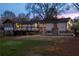 Exterior of the stylish home featuring a stone fireplace, deck, and sunroom in the fenced backyard at 1199 Murray Sw Cir, Marietta, GA 30064