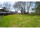 View of sprawling backyard with large lawn, mature trees, deck, and outdoor living space at 1199 Murray Sw Cir, Marietta, GA 30064