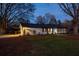 Charming white brick home featuring a well-maintained lawn and string lights in the evening at 1199 Murray Sw Cir, Marietta, GA 30064