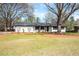 Charming white brick home featuring dark trim, decorative lattice, and manicured front lawn at 1199 Murray Sw Cir, Marietta, GA 30064