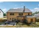 Backyard view of a tan home with a grey roof, a patio with an outdoor table and chair set and grass at 1249 Austin Thomas Dr, Dacula, GA 30019