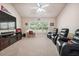 Living room with carpet flooring, a ceiling fan and recliners facing a television above an electric fireplace at 1249 Austin Thomas Dr, Dacula, GA 30019