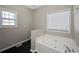 Bathroom featuring soaking tub, tile floors, and two windows for natural light at 274 Sleepy Hollow Rd, Powder Springs, GA 30127