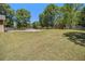Well-maintained backyard with lush grass, a storage shed, and white picket fence under a bright sky at 100 Walnut Ct, Stockbridge, GA 30281