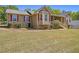 Charming single-story home featuring stone accents, red shutters, bay windows, and a welcoming front porch at 100 Walnut Ct, Stockbridge, GA 30281