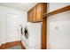 Convenient laundry room with washer, dryer, overhead cabinets and a hanging rack for clothing at 100 Walnut Ct, Stockbridge, GA 30281