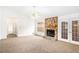 Bright living room featuring a stone fireplace, neutral carpet, ceiling fan, and French doors at 100 Walnut Ct, Stockbridge, GA 30281