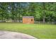 Backyard shed surrounded by lush greenery and a white fence at 100 Walnut Ct, Stockbridge, GA 30281