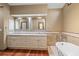 Bathroom featuring granite vanity, white soaking tub, and wood flooring at 2050 Plantation Rd, Lawrenceville, GA 30044