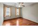 Bedroom with a ceiling fan, hardwood floors, and two large windows for natural light at 2050 Plantation Rd, Lawrenceville, GA 30044