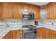 Corner view of the kitchen with stainless appliances and tile backsplash adding style and functionality at 2050 Plantation Rd, Lawrenceville, GA 30044