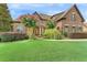 Charming brick home with lush front lawn, blooming trees, and meticulously manicured landscaping at 3284 Kylee Dawn Cir, Lawrenceville, GA 30045