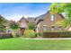 Beautiful brick home with a manicured lawn, blooming trees, and charming architectural details at 3284 Kylee Dawn Cir, Lawrenceville, GA 30045