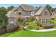 Beautiful brick home featuring a well-manicured lawn and landscaping with flowering trees and shrubbery at 3284 Kylee Dawn Cir, Lawrenceville, GA 30045