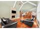Living room with hardwood floors, fireplace, television, leather furniture, and a view to the kitchen at 3284 Kylee Dawn Cir, Lawrenceville, GA 30045