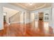 Spacious living room featuring hardwood floors, stone fireplace, staircase, and bright windows at 3284 Kylee Dawn Cir, Lawrenceville, GA 30045