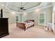 Spacious main bedroom featuring a trey ceiling, neutral carpet, and an abundance of natural light from large windows at 3284 Kylee Dawn Cir, Lawrenceville, GA 30045