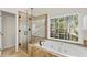Bright bathroom featuring a soaking tub with tile surround and glass shower with decorative tile and black hardware at 3640 Ridgeway Ter, Suwanee, GA 30024