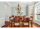 Elegant dining room featuring a classic chandelier, hardwood floors, and ample natural light at 3640 Ridgeway Ter, Suwanee, GA 30024
