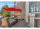 Outdoor patio with stainless steel grill, seating under an umbrella, and wood-look flooring at 3640 Ridgeway Ter, Suwanee, GA 30024