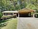 Charming brick home featuring a carport, lush lawn, and mature trees at 942 Ellison Ct, Austell, GA 30168