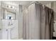 Clean bathroom with white subway tile, a pedestal sink, and a shower with a gray curtain at 215 Piedmont Ne Ave # 2103, Atlanta, GA 30308