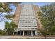 High-rise building surrounded by mature trees and landscaping at 215 Piedmont Ne Ave # 2103, Atlanta, GA 30308