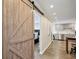 Hallway showcasing a barn door leading to the bedroom, an open kitchen and hardwood floors at 215 Piedmont Ne Ave # 2103, Atlanta, GA 30308